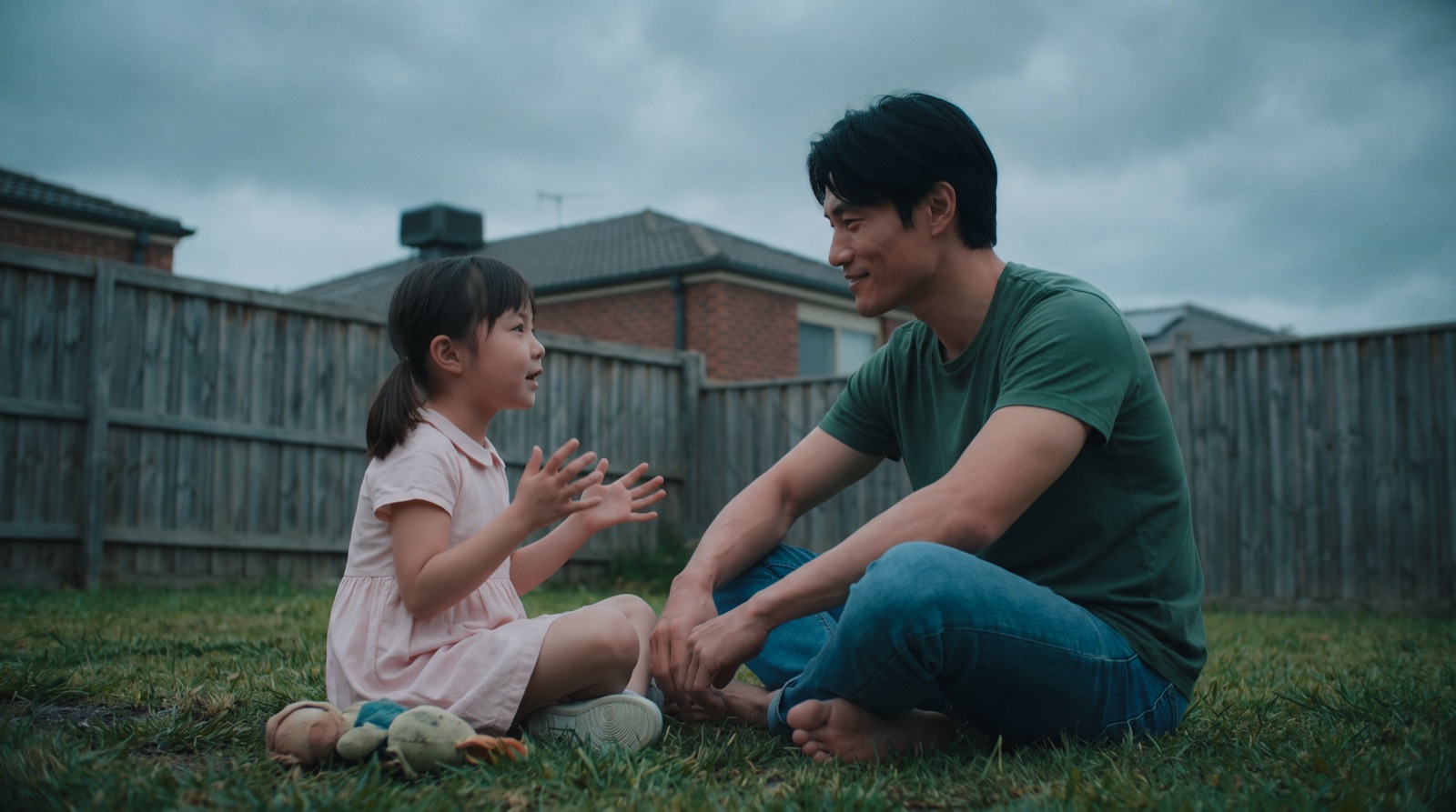 Kai kneels with ten-year-old Mei in a backyard — the breath-count promise